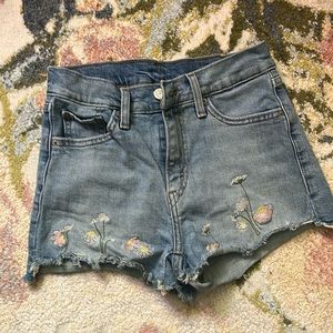 Like new Levi’s shorts with embroidered florals on hem. Size 25.